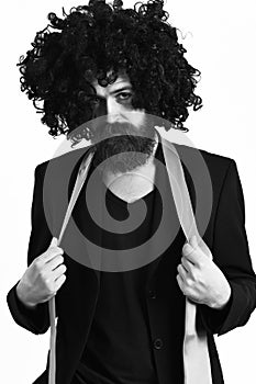 Caucasian hipster in suit and black curly wig
