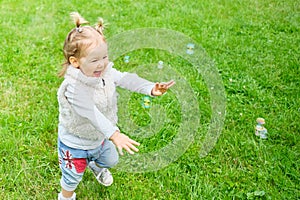 Caucasian kid happy running after soap bubbles