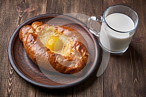 Caucasian kitchen. Khachapuri with the egg and cheese, glass cup