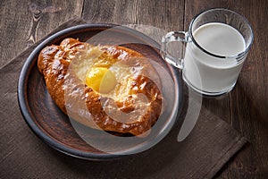 Caucasian kitchen. Khachapuri with the egg and cheese, milk