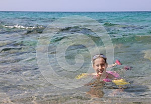 Caucasian littl girl swiming on the sea in summer