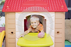 Caucasian little boy playing in a playhouse