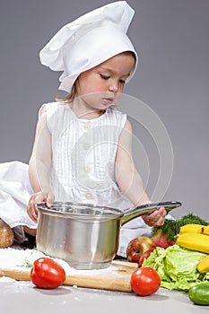 Caucasian Little Girl In Cook Uniform Working With Saucepan