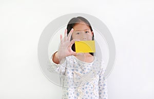 Caucasian little girl kid showing blank yellow card over white background. Focus at card in his hand