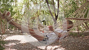 Caucasian little girl relaxing in wicker hammock