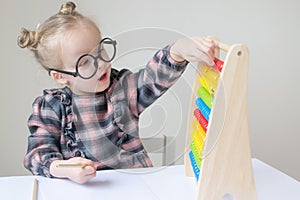 Caucasian little girl with round glasses. Little teacher