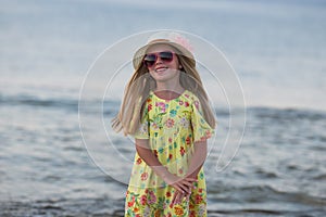 Caucasian little girl smiling happy on sunny summer or spring day outside in park by lake. Pretty girl