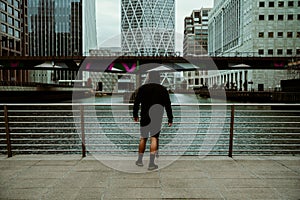 Caucasian male athlete jogging through city taking a breather by bridge photo