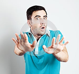 Caucasian male with blue shirt being scared in front of camera