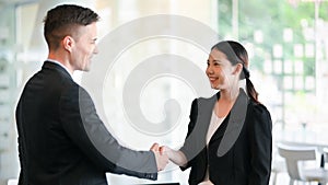 Caucasian male boss greeting and handshaking new employee