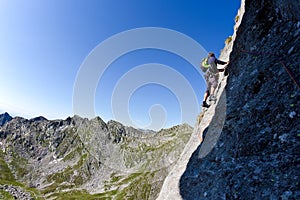 Caucasian male climber climbing a steep wall photo