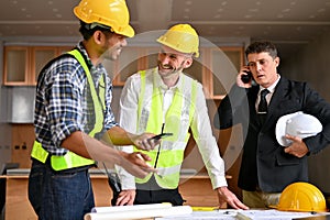 Caucasian male construction engineer manager talking with an Asian male inspector