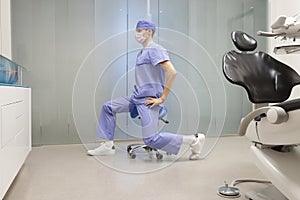 Caucasian male, dentist stretching arms and legs