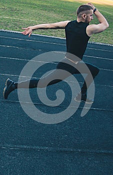 Caucasian male is doing a sprint start. running jumps on the rubber track. Track and field runner in sport uniform. energetic