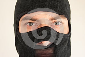 Caucasian male face wearing a black fabric ski mask. Close up shot, unrecognizable