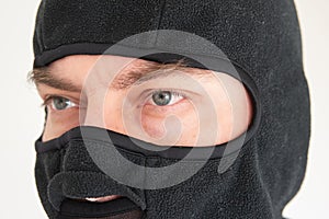 Caucasian male face wearing a black fabric ski mask. Close up shot, unrecognizable