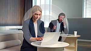 Caucasian male and female employees in formal wear using gadgets for work