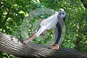 caucasian male in formal clothes doing downward facing dog