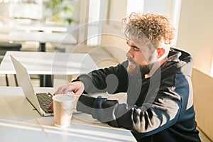 Close-up male guy portrait resting in coffee shop chatting in social networks skilled freelancer enjoying remote job