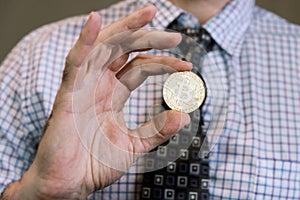 Minted gold Bitcoin token in hand photo