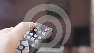 Caucasian male hand holding the TV remote control and turning smart tv on