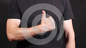 Caucasian male hands in a black short-sleeved T-shirt, pulling a fist