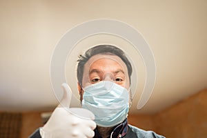 Caucasian male at home during quarantine. Wearing a flu mask and sanitary gloves