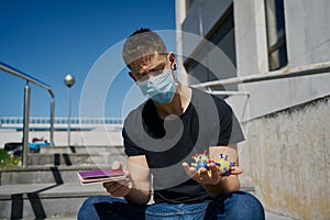 Caucasian male in medical masks with virus mock-ups and passport. Concept of not being able to travel and move around the