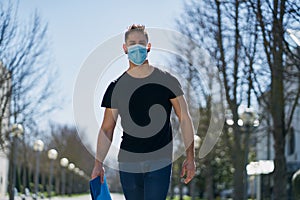 Caucasian male in medical masks walking in a city park. The concept of Coronavirus