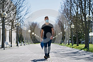 Caucasian male in medical masks walking in a city park. The concept of Coronavirus