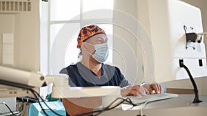 Caucasian male medical worker in operating room in surgical cap and mask. The doctor in the laboratory in front of the