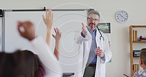 Caucasian male medical worker wearing sthetoscope, standing in classroom asking questions