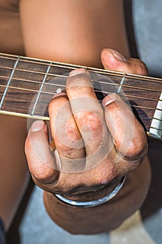 A Caucasian males hands playing an acoustic guitar