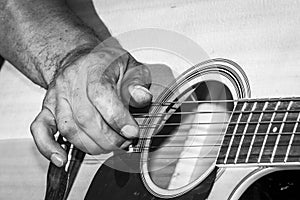 A Caucasian males hands playing an acoustic guitar