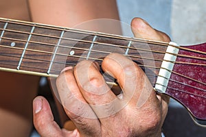 A Caucasian males hands playing an acoustic guitar