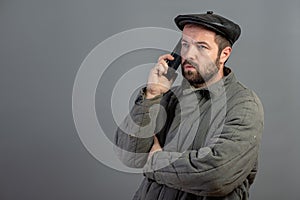 Caucasian man 35 years old with concentrated look at smartphone, studio shot. Idea - village dweller and modern technology