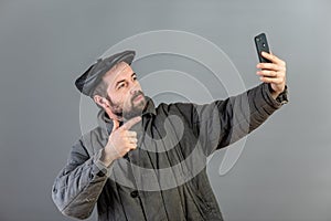 Caucasian man 35 years old with concentrated look at smartphone, studio shot. Idea - village dweller and modern technology