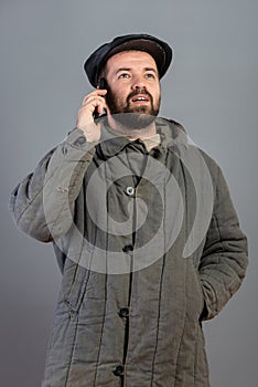 Caucasian man 35 years old with concentrated look at smartphone, studio shot. Idea - village dweller and modern technology