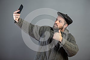 Caucasian man 35 years old doing selfie, studio shot. Idea - village dweller and modern technology