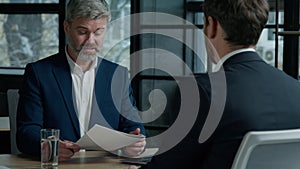 Caucasian man businessman investor client reading document signing contract men business partners make deal at office