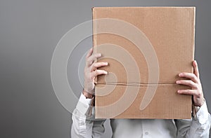 Caucasian man with a cardboard box over his head