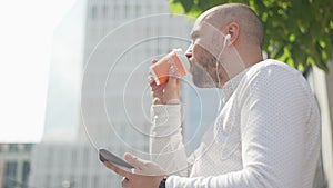 Caucasian man in casual clothes listening to music in headphones