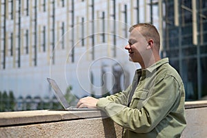 Caucasian man communicates in sign language via video link on laptop.