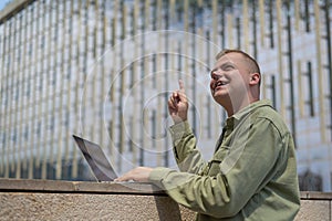 Caucasian man communicates in sign language via video link on laptop.