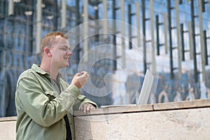 Caucasian man communicates in sign language via video link on laptop.