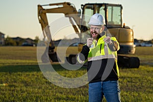 Caucasian man, construction worker in helmet at construction site. Industry engineer worker in hardhat near bulldozer or
