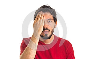 Caucasian man covers an eye with his hand. eyesight test chart.