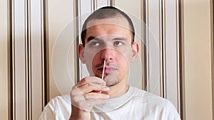 A caucasian man does an antigentest for coronavirus. The stage of collecting a smear from the nasopharynx