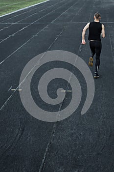 Caucasian man doing a sprint start. running on the stadium on a track. Track and field runner in sport uniform. energetic physical