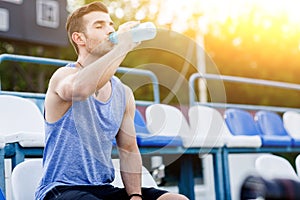 Caucasian man drinking water with his eyes closed after exercises